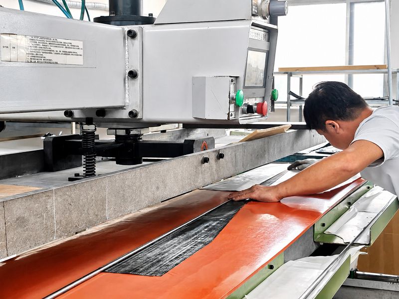 Carbon fiber material being rolled onto a fishing rod mandrel Carbon fiber material being rolled onto a fishing rod mandrel